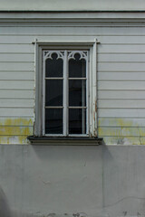 Obraz premium Traditional historic wooden window with decorative gothic style ornaments on a white building facade