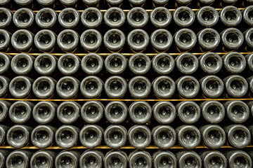 Vintage bottles in cellar, Old wine bottles arranged on wooden racks, Dustcovered wine bottles stored in rustic underground cellar