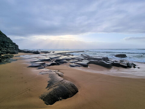 Rocks on Bar Beach Newcastle New South Wales Australia. Low tide early morning with a grey cloudy sky.
