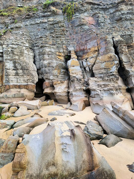 Eroded cliff face at Bar Beach Newcastle New South Wales Australia. Early morning with a grey cloudy sky.