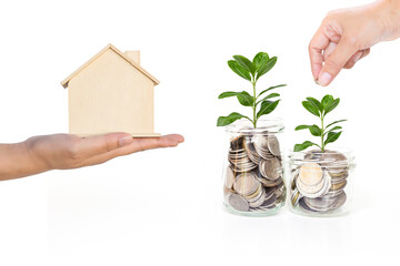 Wooden house model and Coin in girl hand with jar full of coins with green plant isolate on white background, saving money for new hosue, property investment