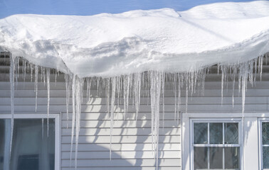 winter house with icicle and snow on the roof