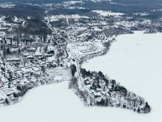 Fototapeta premium Aerial winter view of Waterloo town with frozen lake, snowy houses and roads, Quebec, Canada. g.