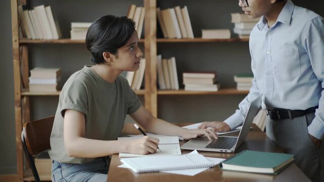 Tutor guiding a student with her assignment