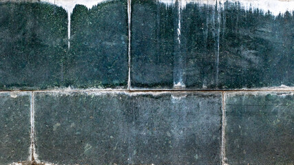 Weathered dark green stone wall with streaks and grunge texture