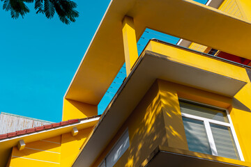 Vibrant yellow modern architecture against clear blue sky