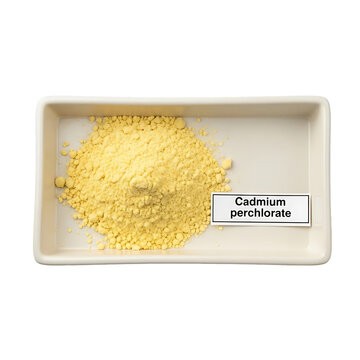 A pile of yellow cadmium perchlorate powder in a white rectangular container with a label against a plain white background from a top-down viewpoint