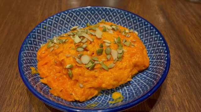 Close-up of gajar ka halwa, a traditional Indian carrot dessert, served in a bowl and garnished with nuts. Popular sweet dish prepared during festivals, celebrations, and family meals