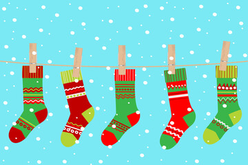 Colorful Christmas stockings hanging on a clothesline against a snowy turquoise background