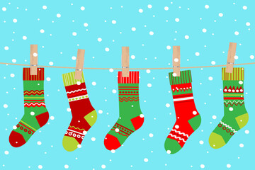 Colorful Christmas stockings hanging on a clothesline against a snowy turquoise background.eps