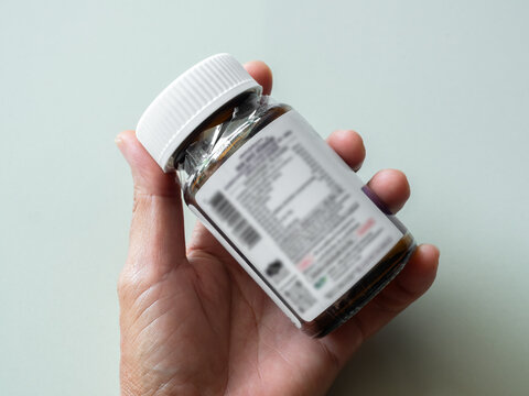 Expire drugs check, finger woman holding bottle mfg and exp date infomation, supplement food product, blur medicine label, blur text.