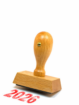 Holzstempel mit dem Aufdruck 2026 vor wei&szlig;em Hintergrund