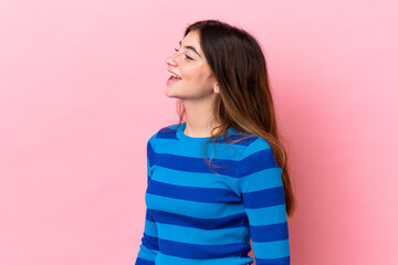 Fototapeta premium Young caucasian woman isolated on pink background laughing in lateral position