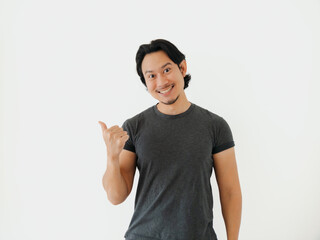 Portrait of personable Asian man displaying thumbs up gesture