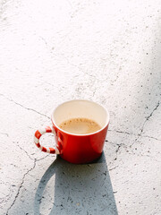 Urban coffee break illuminated by sunlight on rough concrete surface
