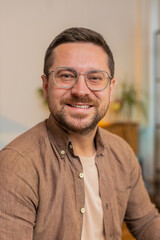 Obraz premium Portrait of happy calm young businessman at home smiling friendly, glad expression looking dreaming resting, relaxation feel satisfied concept good news, celebrate win. Caucasian guy in living room