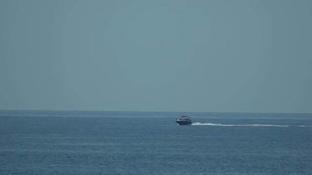 Boat, ocean, water, small boat cruising across vast blue sea under clear sky