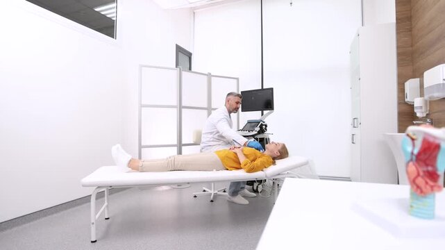 Doctor making ultrasonography to female patient at ultrasound office of medical clinic with anatomical model of thyroid in table. Ultrasound diagnostics of thyroid gland