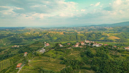 Obraz premium AERIAL: Beautiful village on top of small hill in the embrace of wine country