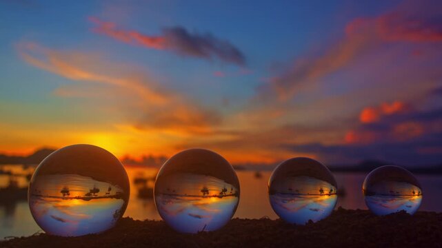 The serene beach transforms into a gallery of light as four crystal balls reflect the sunset&rsquo;s warm tones. A poetic balance of nature and art unfolds in every refracted beam of golden glow.