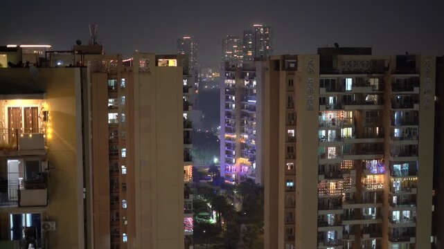 Multi storey floor skyscraper at night with light decorations and fireworks in the distance showing the view in delhi, India, Noida, Gurgaon during Diwali, Dussehra, New Year