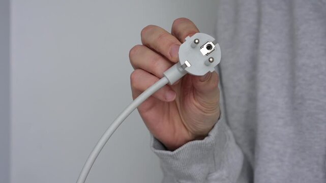 A charging cable for electrical appliances.
An electrical plug on a gray background