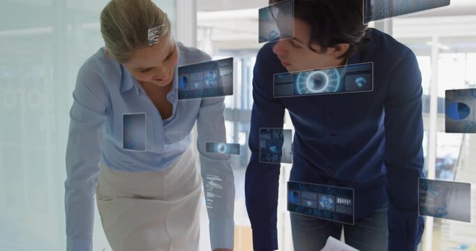 Animation of radar, globe, graphs, computer language over caucasian coworkers discussing blueprint