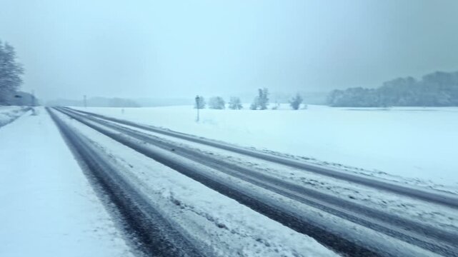 winterliche verschneite Landstra&szlig;e: Auto, Stra&szlig;enverkehr, Glatteis, Schneematsch und eisige Bedingungen, Wintersdienst, Sicherheit, Unfallgefahr, Transport, Landschaft

