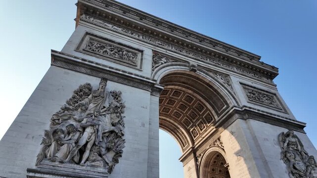 Iconic arc de triomphe monument in paris celebrating french history and national identity with its detailed neoclassical architecture and historical sculptures against a clear blue sky