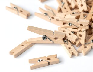 A Close-Up Shot of a Pile of Natural Wooden Clothespins Scattered on a White Background, Perfect for Laundry and Crafting Needs