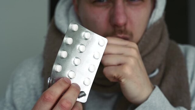 Cough drops for a fighting guy.
A man with a sore throat.
Colds and their treatment with pills.
Painkiller pills in blister packs.