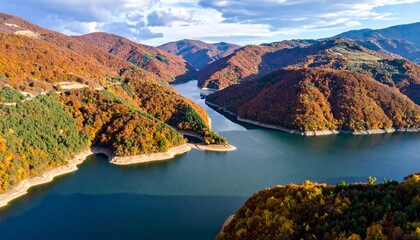 Naklejka premium Serene Aerial View of Autumnal Lake Scenery with Colorful Forests and Dramatic Clouds in a Remote Location.