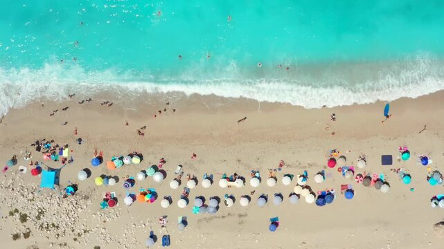 Greek island dream vacation shallow turquoise crystal water on white beach in Greece Mediterranean landscape drone shot at Lefkada beach. Aerial overhead top view from sea beds with umbrellas coastal 