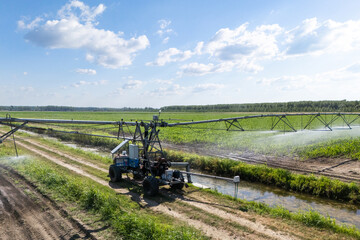 Fototapeta premium Autonomous machine is moving watering pivot along irrigation canal