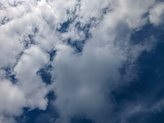 Fototapeta premium View of blue sky with fluffy white clouds creating a calm natural background, suitable for weather, environment, freedom, climate and peaceful outdoor concepts.