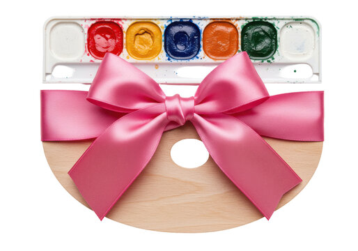 Pink ribbon adorned watercolor palette and wooden art palette isolated on white background
