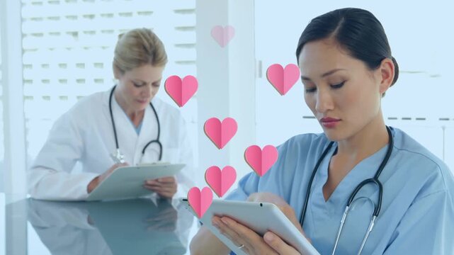 Animation of hearts floating over diverse female doctors making notes