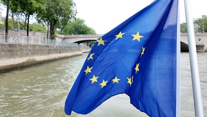 European union flag on a boat cruising the historic seine river in paris, representing european culture, unity, travel, and international relations