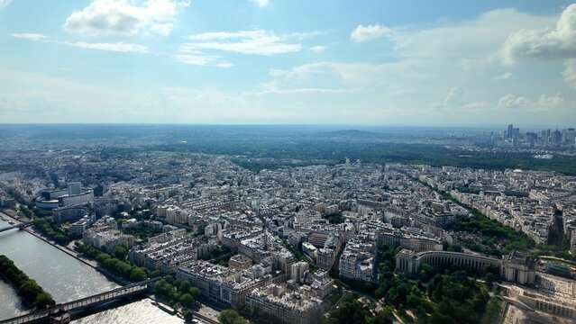 Paris urban landscape creating a dense cityscape with the seine river, bridges, and bois de boulogne, extending towards the district of la d&eacute;fense under a clear sky
