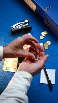 Finanzas contando dinero en monedas y billetes de euro y cuenta con operaci&oacute;n de suma en calculadora m&oacute;vil