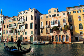 Obraz premium Gondola passing historic buildings along a Venetian canal