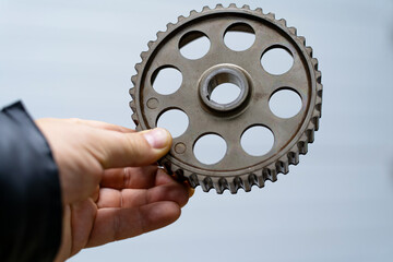 The hand of a master holds a gear