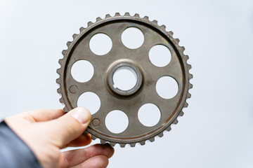 The mechanic's hand holds a gear