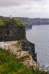 a rainy and stormy summer day at the famous cliffs of moher in the irish County Clare. A View to the famous O'Briens tower next to the cliffs. 