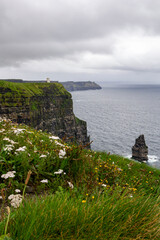 a rainy and stormy summer day at the famous cliffs of moher in the irish County Clare. A View to the famous O'Briens tower next to the cliffs. 
