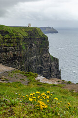 a rainy and stormy summer day at the famous cliffs of moher in the irish County Clare. A View to the famous O'Briens tower next to the cliffs. 