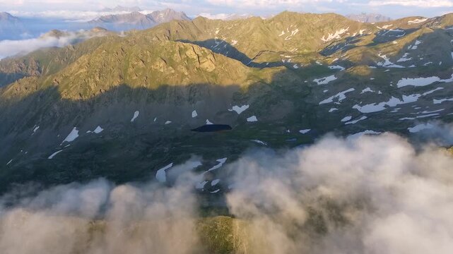 Aerial view of high altitude mountain tarn lakes within the Rocky Mountains wilderness summer light. Clear water and rugged alpine terrain reveal pristine glacial basins and remote peaks.