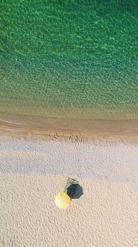 Aerial Top Down Scene of Yellow Umbrella and Mat on Greek Island Beach