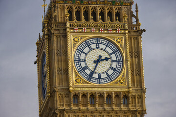 Big Ben clock tower on a sunny day with a blue-grey sky, close-up.