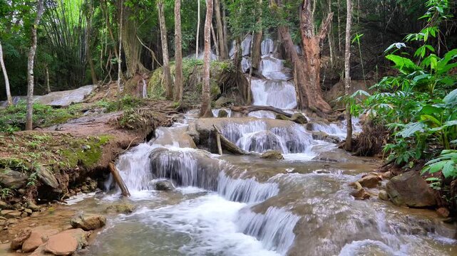 Pha Tat Waterfall, Kanchanaburi Province, Thailand. Video of a large waterfall in the middle of a lush green forest, with the sound of the waterfall. 4k
